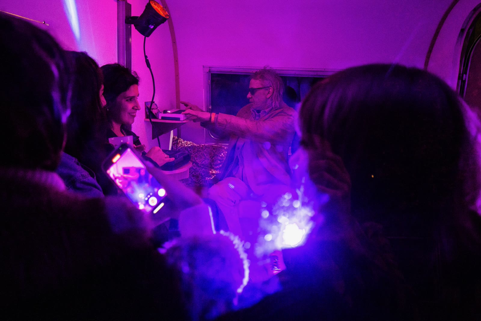 Public à l'intérieur de la caravane sous lumière violette