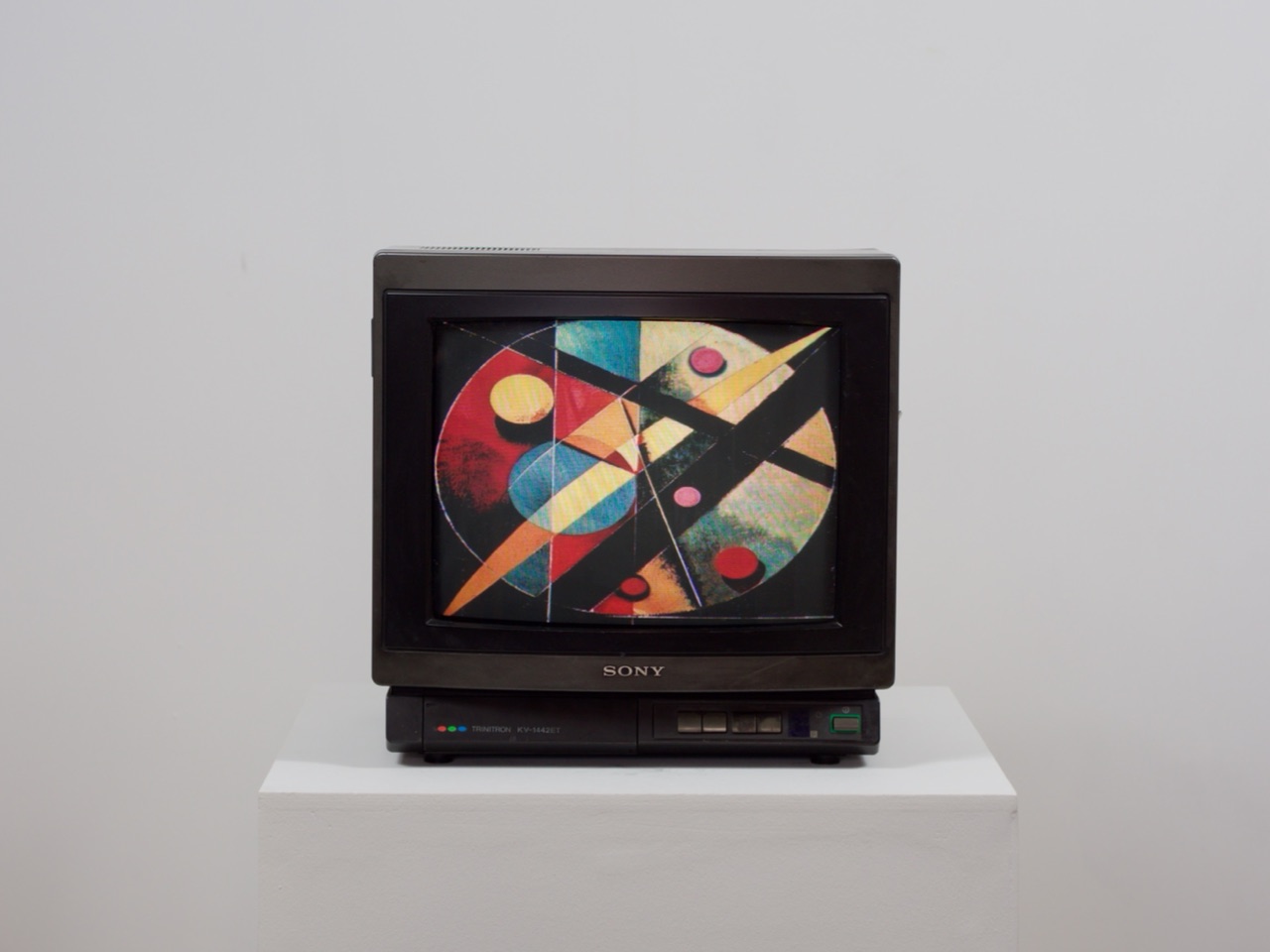 Le téléviseur affiche des cercles et des diagonales noires sur fond crème, dans l'esprit de Kandinsky